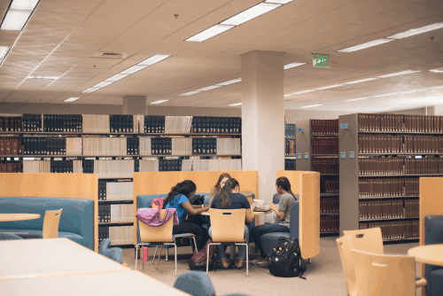 students working at a table in the library